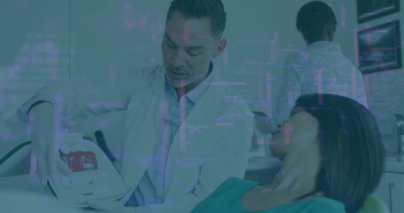 Explaining dentist in white lab coat showing panel by dental chair, with protective bib