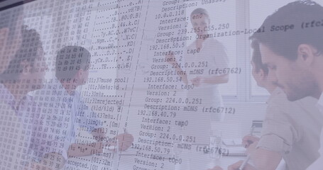 Collaborating IT professionals analyzing network data in meeting room, with laptops and flip chart