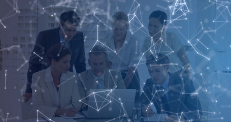 Six professionals in suits analyzing data around silver laptop in boardroom, with network overlay