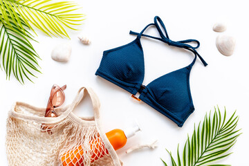 Bikini swimsuit with and palm leaves with beach accessories. Flat lay, top view
