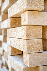 Stacked stone bricks are arranged in a staggered pattern creating a textured wall. Construction material, texture, architecture, close-up, pattern