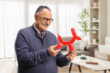 Mature man looking at a red balloon