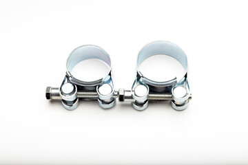 Metal pipe clamps designed for securing pipes. The clamps are shiny and cylindrical, 