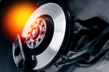 Close-up of car brake disc and wheel service with glowing heat effect
