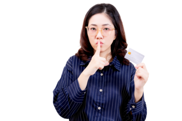 Asian young beautiful woman wearing glasses holds a credit card and gestures for silence with her finger to her lips.