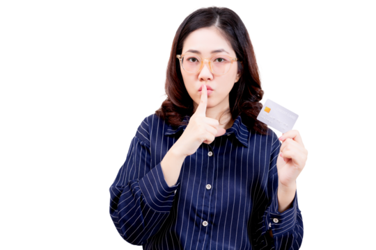 Asian young beautiful woman wearing glasses holds a credit card and gestures for silence with her finger to her lips.