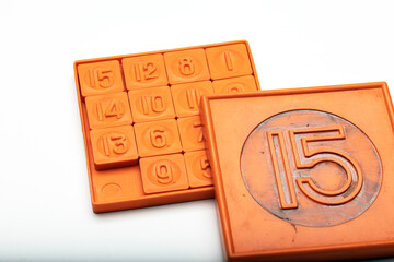 A classic 15-puzzle game with orange tiles. The puzzle consists of numbered squares arranged in a grid, with one empty space for movement.