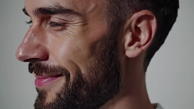 Man portrait closeup showing beard and eyes. Male model half face. Confidence in expression. Man hair and lips visible. Beard emphasized in detail. Closeup eyes and beard. Confidence and style beard.