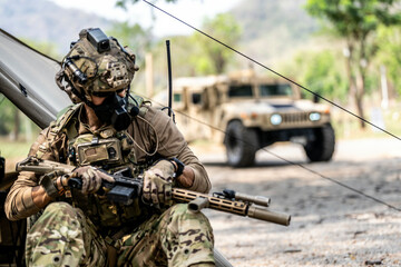 Elite Special Forces Soldier in Tactical Gear Preparing Weapon – Combat Mission Readiness Near...