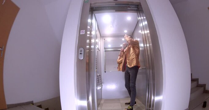 In this short clip, a man showcases dance moves in an elevator while wearing a mask. He relaxes and chats on his phone with a woman present, creating a dynamic interplay of emotions