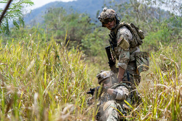 Special forces soldier holding rifle and communicating on radio during tactical operation in...