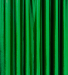 green satin theater drapes or stage curtains, full frame, evoking elegance, drama, and luxury....