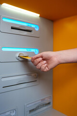 Banking customer inserting credit card into ATM, performing electronic financial transaction with...