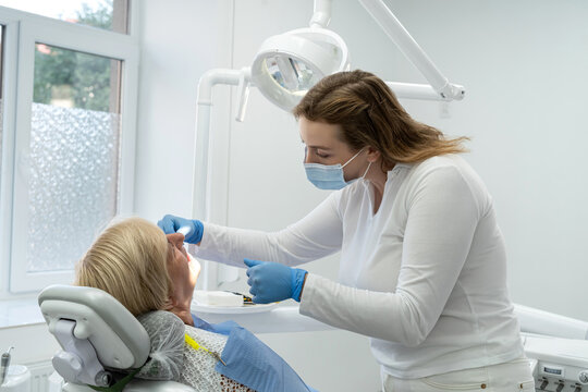 Senior female client having repairing tooth at dentist's office. Concept of ready for teeth cure
