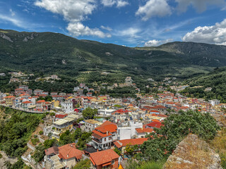 Panoramic view of Parga, a picturesque coastal town in Greece, famous for its colorful houses with red-tiled roofs nestled in a lush green mountain valley.