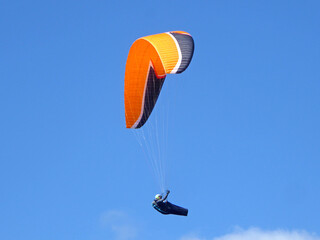 Paraglider flying in a blue sky	