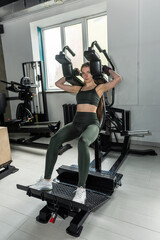 caucasian fitness woman doing execute exercise work-out with machine in gym