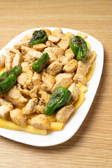 Delicious dish of chicken with padron peppers and fries, a typical spanish tapa, perfect for sharing