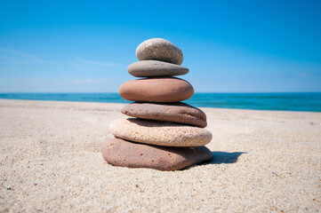 Balanced rock pyramid on sea sand beach