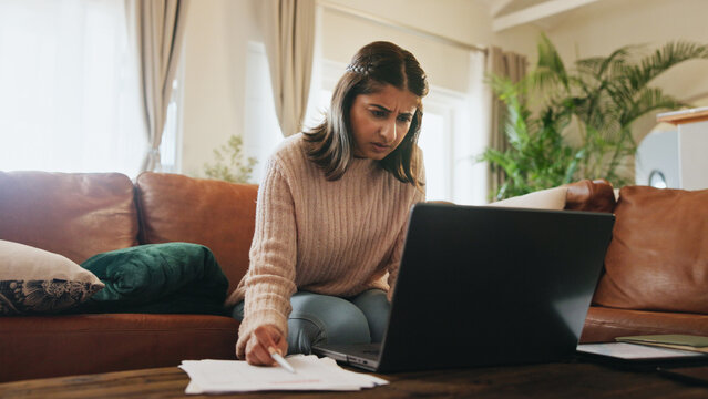 Woman, finance and stress with laptop in home with documents, debt or fintech for payment on sofa. Person, paperwork and confused with review, bills or computer for credit score on couch at apartment