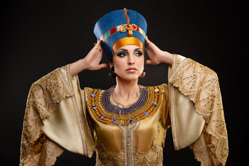 Studio portrait of a beautiful woman Queen Nefertiti. Cleopatra holding her crown.