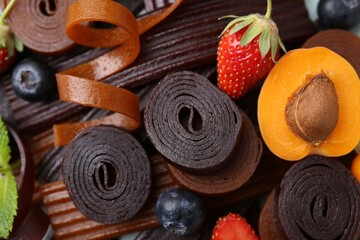 Tasty candied leather rolls, fruits and berries, closeup