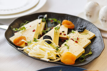 Cheese platter served on a dish on a white table