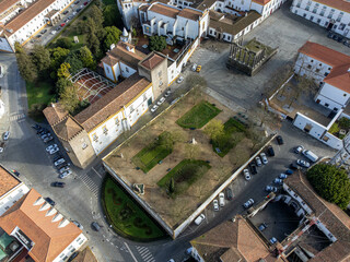Aerial view of Jardim Diana in &Eacute;vora, Portugal, with Roman Temple ruins and historic architecture surrounded by green trees and cobbled streets.