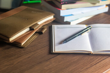 Several stacks of books and pencils are on the wooden table, education concept