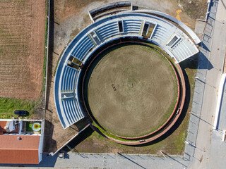 Aerial view of the bullring in Aldeia da Luz, Mourão, Alentejo, Portugal. Captured by drone, showing traditional architecture and rural landscape.