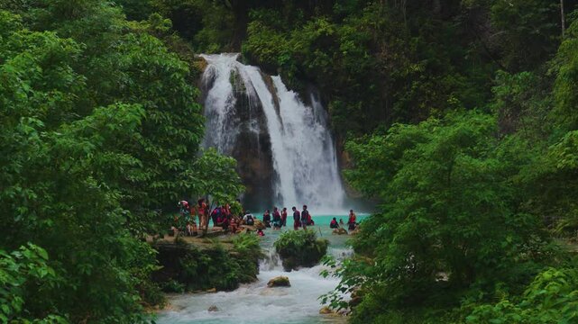 Wide View of Kawasan Falls with Tourists Enjoying the Jungle Waterfall and Turquoise River in Cebu, Philippines