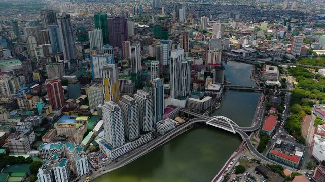 Aerial view of Binondo&rsquo;s modern skyline and bridges over the Pasig River with a dense urban sprawl and mountains in the distance &ndash; Manila, Philippines