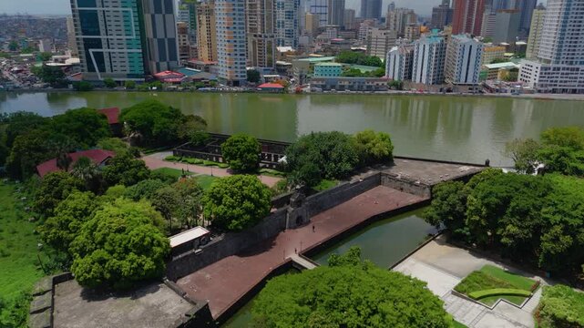 Aerial view of Fort Santiago&rsquo;s stone walls and lush gardens beside the Pasig River with Manila's modern cityscape in the background &ndash; Intramuros, Manila, Philippines