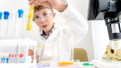 A boy student conducts chemical experiments in a chemical laboratory