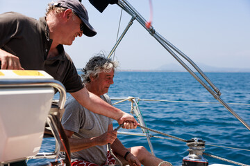 Mature friends enjoying sailing trip on Costa Brava, Girona, Spain