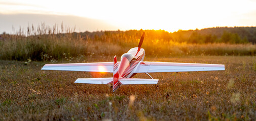 Model of an airplane on a field during sunset