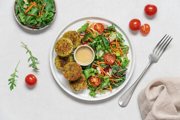 Vegan falafel with healthy mix of green lettuce, carrot, beetroot and tomatoes. Healthy food white background with copy space