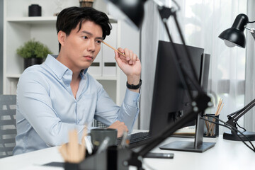 Serious smart businessman working on computer to check email with business project report,...