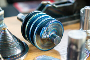 Objects printed on 3D printer from filament of molten metal on table. Object printed by 3D printer from metal. Additive manufacturing solution. Object created on 3D printer from melting metal thread