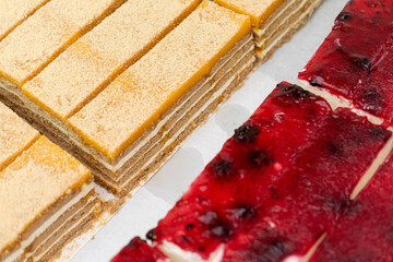 Slices of classic Portuguese bolo de bolacha and creamy strawberry cheesecake on a white plate, showcasing delicious layered desserts with rich textures and vibrant colors.
