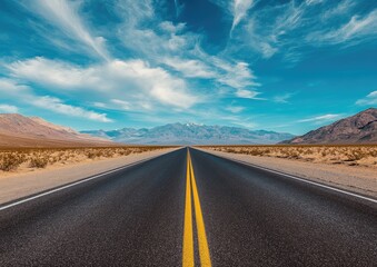 Naklejka premium Empty highway stretching into distant mountains under a vast sky