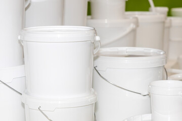 New white unmarked plastic round containers and buckets of various sizes designed for storing and transporting food and liquids