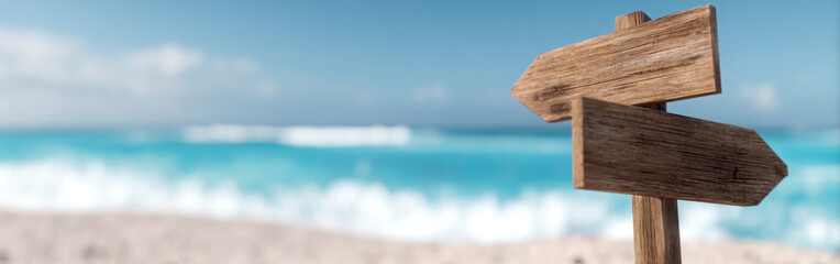 Fototapeta premium Wooden signpost on a serene beach with gentle waves and a clear sky inviting travelers to explore the coast. summer background concept, banner, copy space, empty space for text