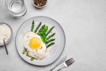 Fried egg with green asparagus and grated parmesan cheese for braekfast