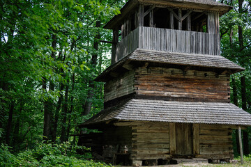 Rustic wooden structure amidst lush green forest in a tranquil setting
