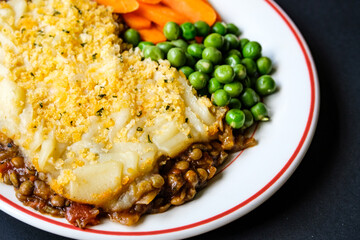 Vegetarian or Veggie Cottage Pie With Carrots And Peas Topped With Mash Potato