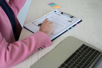 A young asian female Head of HR is reading resume and making a call for the recruitment interview  process with the candidate who has been selected to work in the company, employment and HR concept.