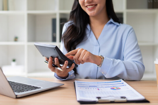 Female employee holding a calculator checking and calculating accounts