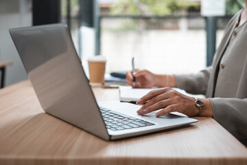 Young woman's hand pressing a button on a laptop keyboard