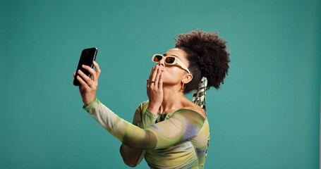Selfie, kiss or woman in studio with fashion, photograph or trendy clothes on green background....